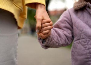 A close up of a hand holding a child.